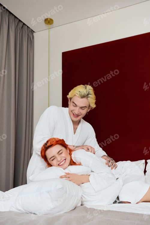 Preview: Young couple enjoying a blissful summer vacation in a modern hotel room