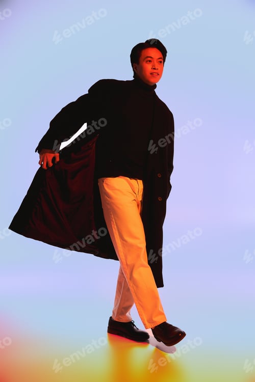 Preview: Stylish young man showcasing unique fashion in a vibrant studio setting