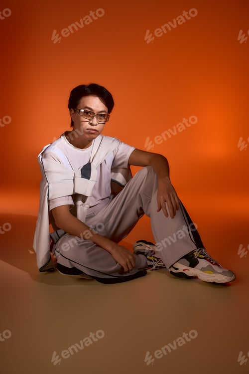 Preview: Young man showcases unique fashion style in vibrant studio setting