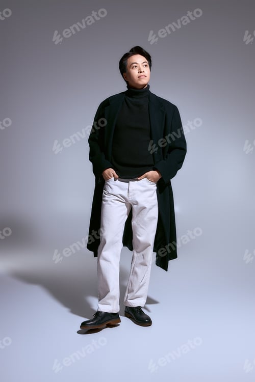 Preview: Young man elegantly displays modern fashion in contemporary studio setting