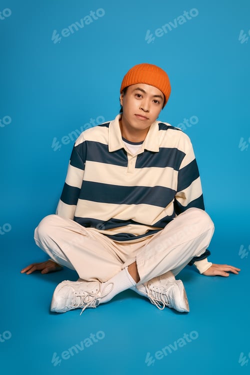 Preview: Stylish young asian man expresses unique fashion in vibrant studio setting