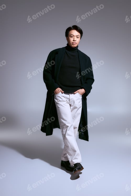 Preview: Stylish asian young man showcases modern fashion in a creative studio setting