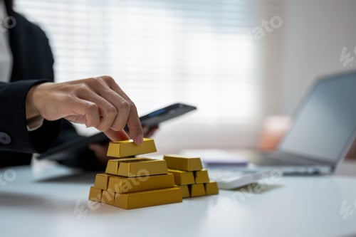 Preview: Gold investment concept with businesswoman analyzing market data on tablet, stack of gold bars.