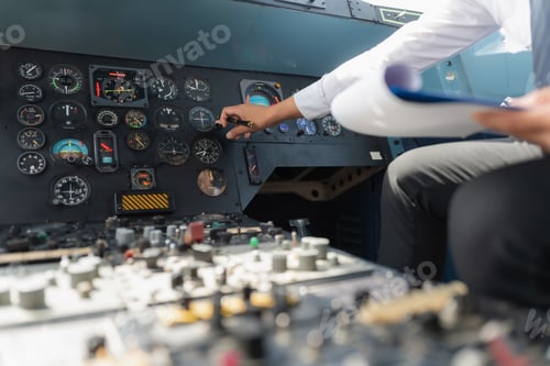 Preview: Portrait of a trained airplane captain in uniform preparing to fly in a simulator cockpit.