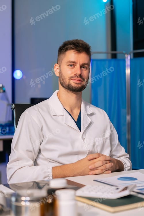Preview: Portrait of a male doctor thinking and looking out the window during the day.