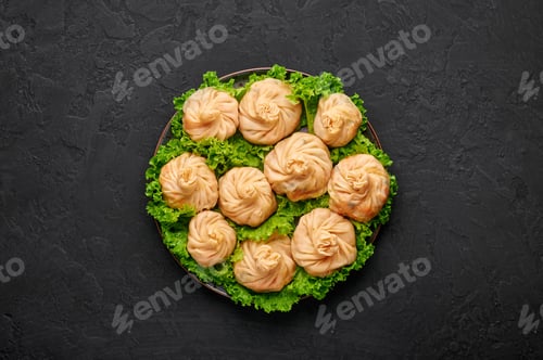 Preview: Veg Momos on black slate table top. Vegan Tibetan and Nepali dumplings filled with vegetables