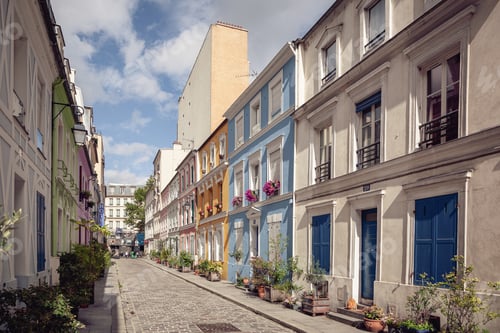 Preview: Charming cobblestone lane of Rue Crémieux lined with colourful pastel residential houses and potted