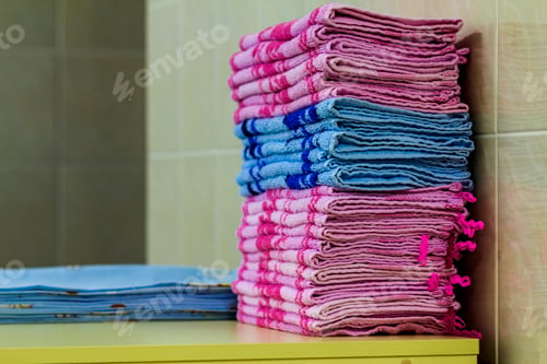Preview: Stack of pink bath towels close-up with blurred background