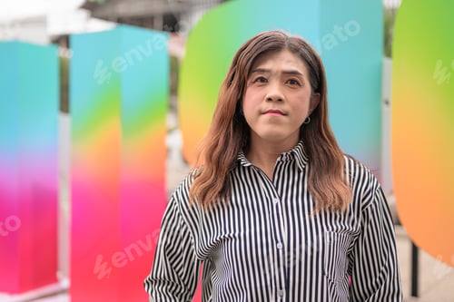 Preview: Thai transgender woman standing before a colorful Pride month display