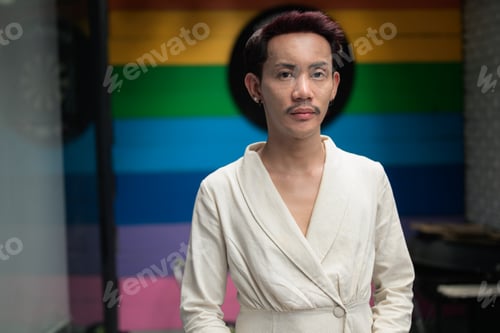 Preview: Non-binary gay Thai man from Isan standing in front of a rainbow pride background, showcasing authen