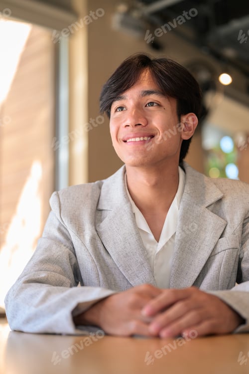 Preview: Portrait of smiling non-binary Thai Isan professional in cafe