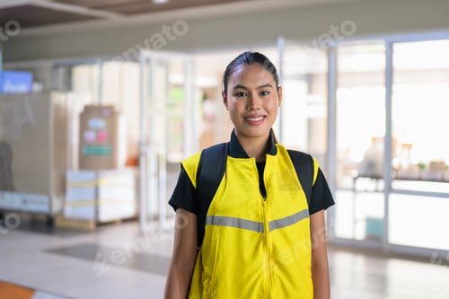 Preview: Smiling Female Delivery Courier Outside Office Building Lobby