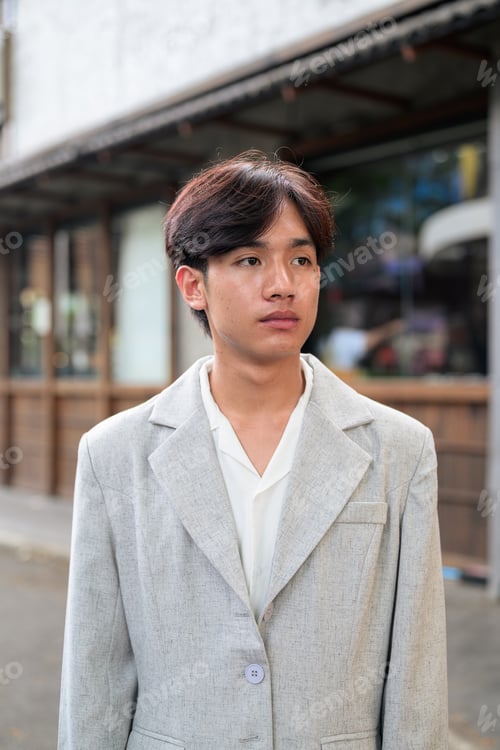Preview: Portrait of non-binary Thai Isan professional looking away outdoors