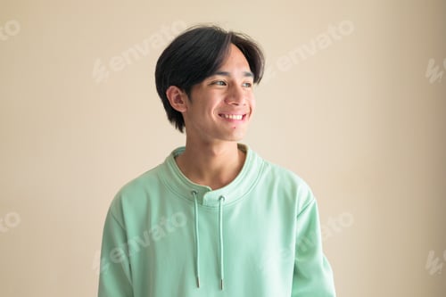 Preview: Portrait of a happy young Thai man from Isan smiling and looking away