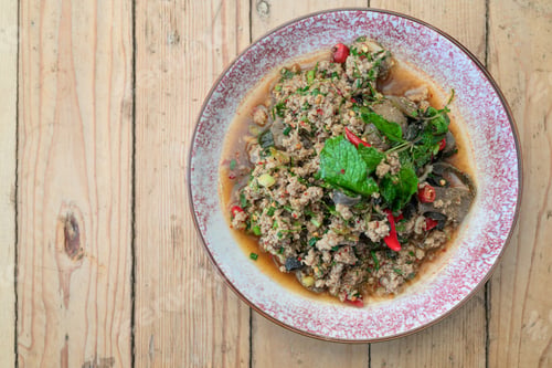 Preview: Authentic Thai Beef Larb Salad Laab Neua Spicy Ground Meat Dish on Wooden Table with Copy Space