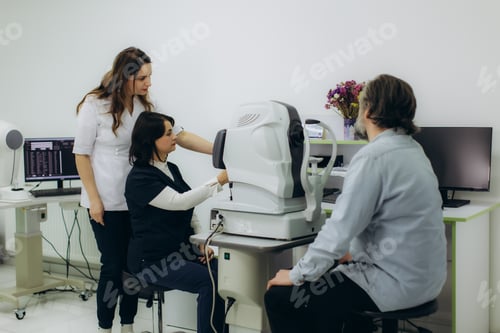 Preview: Ophthalmologist team performing eye exam on patient