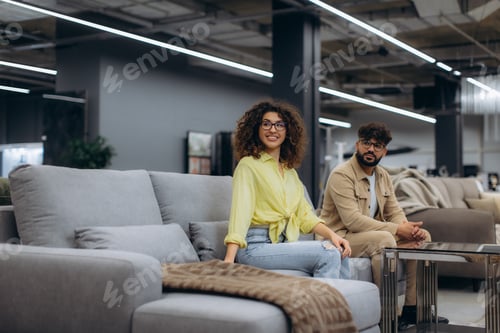 Preview: Couple shopping for furniture, sitting on a sofa