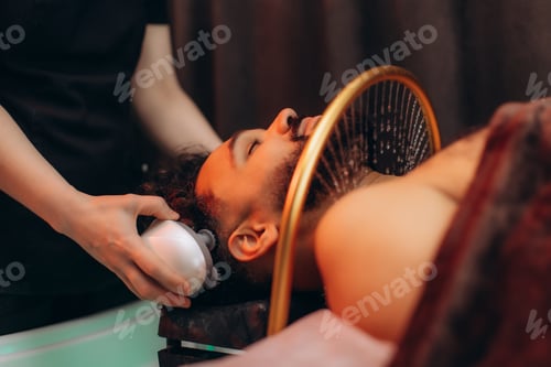Preview: Man receiving professional scalp treatment and water therapy