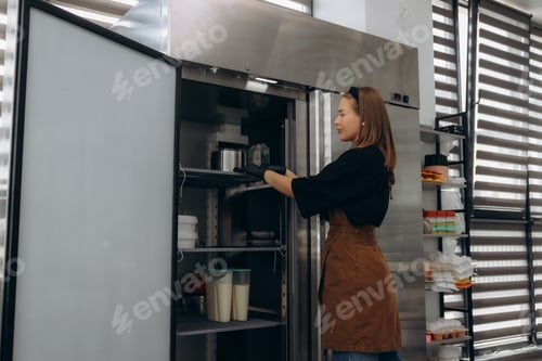 Preview: Pastry chef organizing professional kitchen refrigerator storage