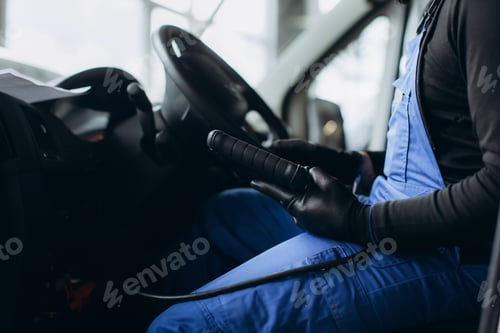 Preview: Auto mechanic performing car diagnostic using scanner