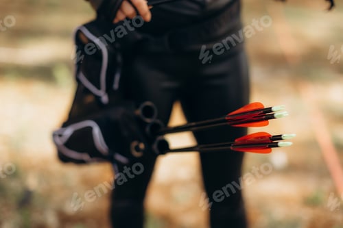 Preview: Archer preparing multiple arrows with red fletching for outdoor target practice