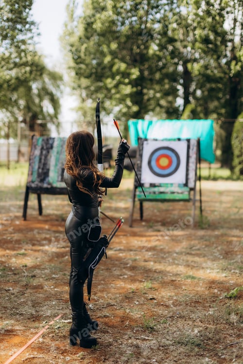 Preview: Woman preparing to shoot arrow during archery practice