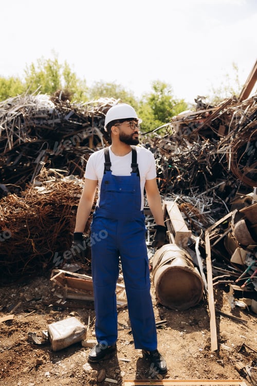 Preview: Worker standing among scrap metal pile
