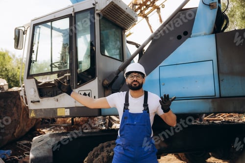 Preview: Construction worker standing with heavy machinery on site
