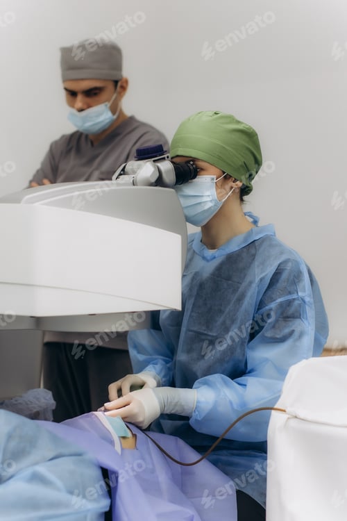 Preview: Ophthalmologist performing eye surgery with microscope