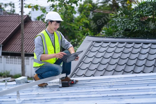 Preview: Asian Male Roofer Inspector Using Tablet on Rooftop During Construction Inspection with Safety Helme