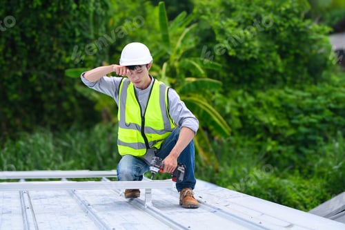 Preview: Asian Construction Worker Using Drill on Metal Roof Structure Outdoors