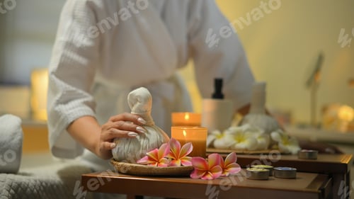 Preview: Spa setup with herbal compress candles flowers and relaxing wellness mood