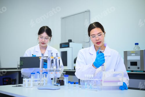 Preview: Two Asian Female Scientists Working in Modern Laboratory with Pipettes and Test Tubes
