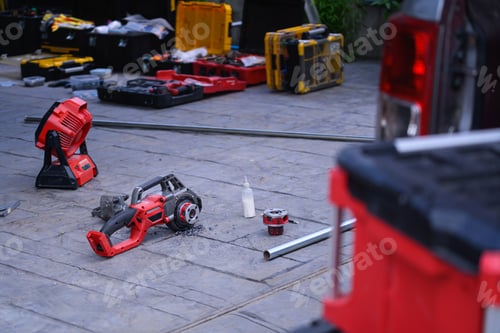 Preview: Professional Power Tools and Toolboxes Spread on Outdoor Pavement During Construction Work