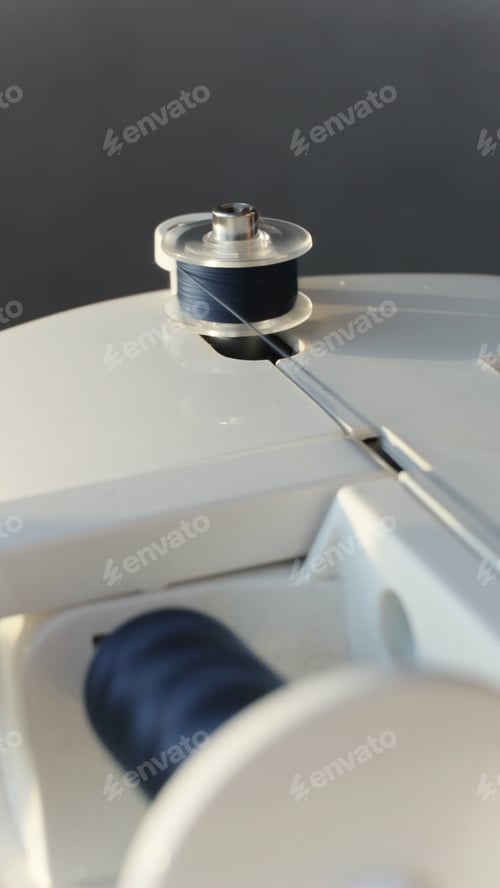 Preview: Bobbin for a Sewing Machine Winds Dark Blue Threads for Sewing.