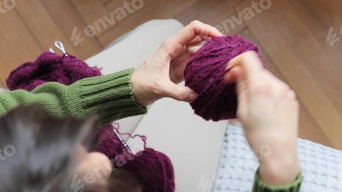 Preview: Women's Hands Wind Wool Yarn Into a Ball. Woman Knits Wool Clothes on Knitting Needles.