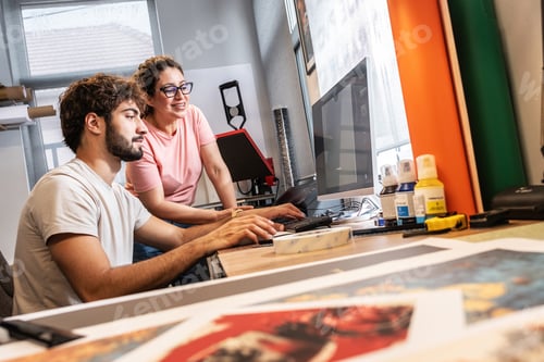 Preview: Two colleagues in a print shop work together on preparing a branding project for production.