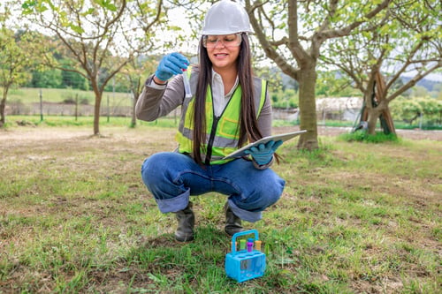 Preview: Female environmental engineer testing soil pollution in field