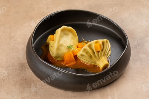 Preview: Khinkali dumplings with sauce in black bowl