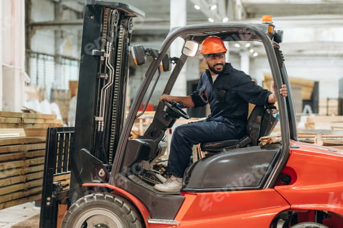 Preview: Driving, skilled employee. Warehouse worker operating a forklift while handling wooden materials