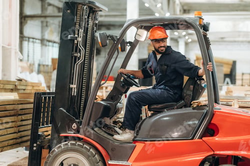 Preview: Driving, skilled employee. Warehouse worker operating a forklift while handling wooden materials