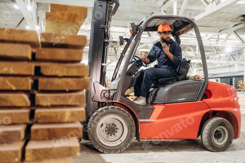Preview: Heavy material, lifting the planks. Warehouse worker operating a forklift while handling wooden mate