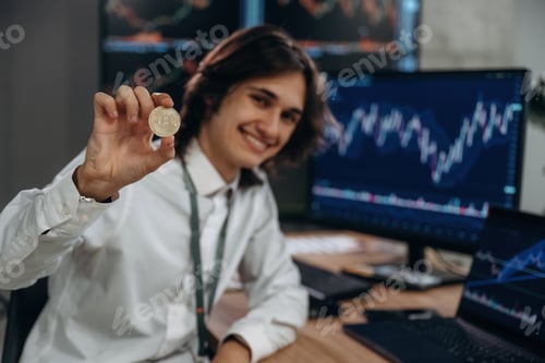 Preview: Investment concept, holding coin of crypto currency. Young man is sitting in the office with multipl