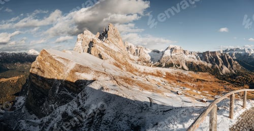 Preview: Panoramic view of Seceda in the Dolomites covered with first snow, dramatic sky and soft golden hour