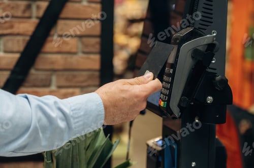 Preview: Side close up view of man that is paying in grocery store by using credit card