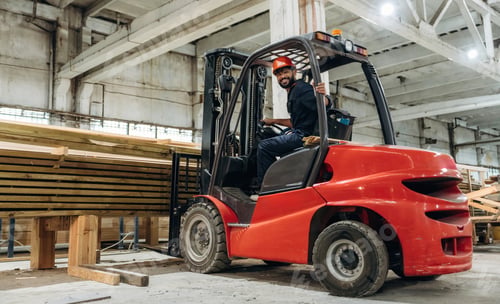 Preview: Lifting bunch of planks. Warehouse worker operating a forklift while handling wooden materials