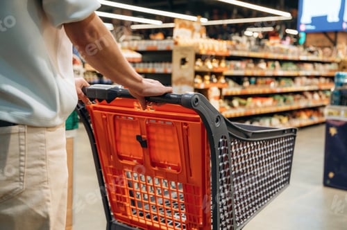 Preview: Individual pushing shopping cart through grocery store aisle filled with various products, showcasin