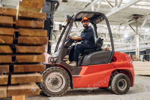 Preview: Warehouse worker operating a forklift while handling wooden materials