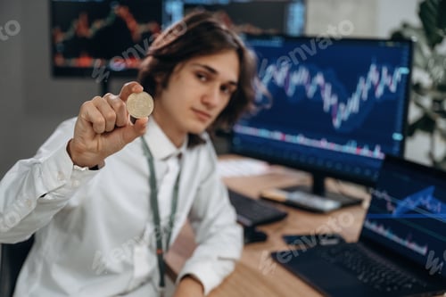Preview: Investment concept, holding coin of crypto currency. Young man is sitting in the office with multipl