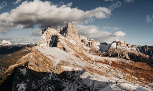 Preview: Panoramic view of Seceda in the Dolomites covered with first snow, dramatic sky and soft golden hour
